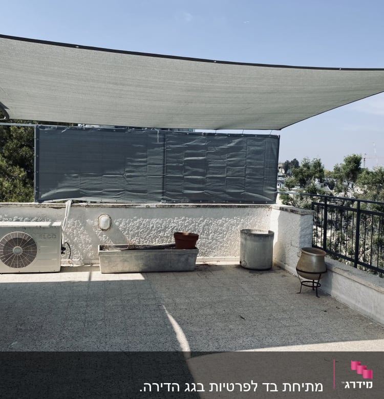 מרפסת עם גדר מתכת ומסגרת צל